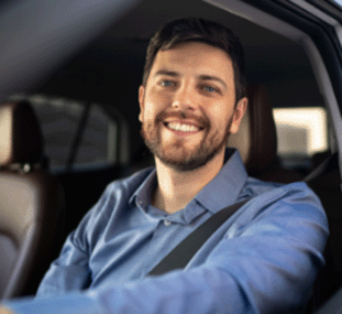A man sitting in the car smiling from the driver's seat