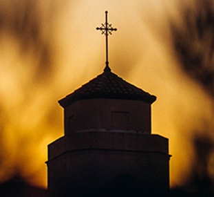 Image of a church in front of a sunset
