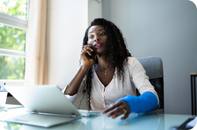 Image of a woman on the phone with a cast on her arm