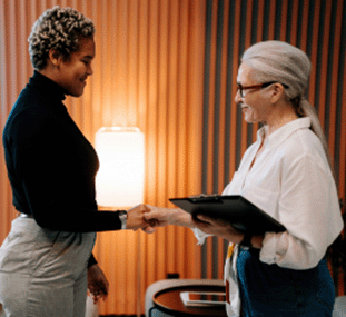 A female employee and a female human resources professional shaking hands